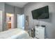 Well lit bedroom with a television, white dresser, and view into the bathroom at 7537 Splashing Rock Dr, Las Vegas, NV 89131
