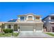 Two-story home with a three-car garage, well-manicured lawn, and solar panels on the roof at 7537 Splashing Rock Dr, Las Vegas, NV 89131