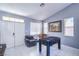 Cozy game room features a foosball table, comfortable seating, and ample natural light from multiple windows at 7537 Splashing Rock Dr, Las Vegas, NV 89131