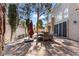 Backyard featuring brick pavers, a dining table, and architectural details of the home at 8215 Crow Valley Ln, Las Vegas, NV 89113