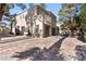 Wide backyard with brick pavers, seating arrangements, and architectural details of the home at 8215 Crow Valley Ln, Las Vegas, NV 89113