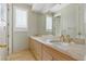 Bathroom with double sinks, marble countertops, light wood cabinets and tile flooring, along with gold fixtures at 8215 Crow Valley Ln, Las Vegas, NV 89113