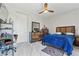 Bedroom with a large window, wood floors, a ceiling fan, and a blue bed, creating a cozy and stylish space at 8215 Crow Valley Ln, Las Vegas, NV 89113