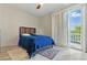 Bedroom with a large window, wood floors, a ceiling fan, and a blue bed, creating a stylish space at 8215 Crow Valley Ln, Las Vegas, NV 89113