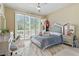 Bedroom with a large window, wood floors, a ceiling fan, and a gray bed, creating a cozy and stylish space at 8215 Crow Valley Ln, Las Vegas, NV 89113