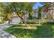 Attractive home with a two-car garage, lawn, and mature trees at 8215 Crow Valley Ln, Las Vegas, NV 89113