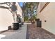 Side view of property featuring brick pavers and exterior appliances along house siding at 8215 Crow Valley Ln, Las Vegas, NV 89113