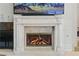 Close up of the marble fireplace with lit fire at 8215 Crow Valley Ln, Las Vegas, NV 89113