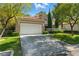 Inviting front exterior with lush lawn, mature tree, and a two-car garage enhancing curb appeal at 8215 Crow Valley Ln, Las Vegas, NV 89113