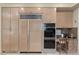Kitchen featuring wooden cabinets, built-in appliances, and a cozy breakfast nook at 8215 Crow Valley Ln, Las Vegas, NV 89113