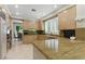 Bright kitchen with stone countertops, custom cabinets, stainless appliances, and an eat-in breakfast bar at 8215 Crow Valley Ln, Las Vegas, NV 89113
