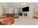 Bright living room featuring a fireplace, travertine floors, wet bar, and a leather sectional at 8215 Crow Valley Ln, Las Vegas, NV 89113