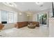 Spacious living room with a leather sofa, a marble fireplace, shuttered windows, and glass sliding doors at 8215 Crow Valley Ln, Las Vegas, NV 89113