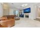 Spacious living room with a fireplace, travertine floors, and comfortable leather furniture at 8215 Crow Valley Ln, Las Vegas, NV 89113