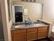 Bathroom featuring double sinks and vanity with granite countertops and wooden cabinets at 8225 Bermuda Beach Dr, Las Vegas, NV 89128
