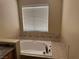 Bathroom featuring a large soaking tub with tiled surround and tile accents at 8225 Bermuda Beach Dr, Las Vegas, NV 89128