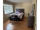 A bedroom featuring hardwood floors, a large window, and a dark wood dresser at 8225 Bermuda Beach Dr, Las Vegas, NV 89128