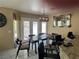 Dining room with a dark table, six chairs, stylish mirror, and a window view to the backyard at 8225 Bermuda Beach Dr, Las Vegas, NV 89128