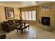 Elegant living room featuring a fireplace, tile floors, and plantation shutters for natural light control at 8225 Bermuda Beach Dr, Las Vegas, NV 89128