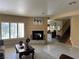 Inviting living room with a cozy fireplace, plantation shutters, and an open layout to the dining area at 8225 Bermuda Beach Dr, Las Vegas, NV 89128