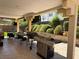 Outdoor patio area with a built-in barbecue, dining table, and lush landscaping at 8225 Bermuda Beach Dr, Las Vegas, NV 89128