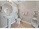 Neutral bathroom with pedestal sink, round mirror, and wood-look tile floors at 8255 Las Vegas Blvd # 809, Las Vegas, NV 89123