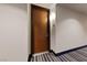 Condo front entrance with striped blue carpet, wood door and modern sconce lighting at 8255 Las Vegas Blvd # 809, Las Vegas, NV 89123