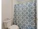 Close-up of the full bathroom with a toilet and shower featuring a decorative blue shower curtain at 8550 Little Fox St, Las Vegas, NV 89123
