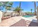 Inviting backyard with lush landscaping, a custom pool, and a rock waterfall feature at 8712 Texas Bronco Ave, Las Vegas, NV 89129