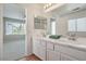 Bright bathroom with a double sink vanity, quartz countertops, and tile flooring at 8712 Texas Bronco Ave, Las Vegas, NV 89129