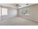 Spacious carpeted bedroom featuring two large windows and a ceiling fan at 8712 Texas Bronco Ave, Las Vegas, NV 89129