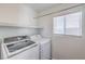 Clean and efficient laundry room with modern washer and dryer, plus storage shelf and natural light at 8712 Texas Bronco Ave, Las Vegas, NV 89129