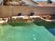 Backyard pool featuring a stone waterfall feature, mature landscaping and desert-style backyard at 8712 Texas Bronco Ave, Las Vegas, NV 89129