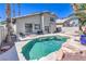 Spacious backyard with a private pool, a rock waterfall, and mature landscaping at 8712 Texas Bronco Ave, Las Vegas, NV 89129