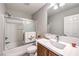 This bathroom features a shower and tub combo, a sink with wood cabinets and neutral paint at 9129 Patrick Henry Ave, Las Vegas, NV 89149