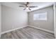 Neutral bedroom featuring wood floors, a window and ceiling fan with lighting at 9129 Patrick Henry Ave, Las Vegas, NV 89149