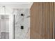 Modern bathroom featuring walk-in shower with stylish tile and wood accent wall at 913 Duckhorn Ct # 201, Las Vegas, NV 89144