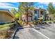 Exterior view of an apartment building featuring lush landscaping and ample parking at 913 Duckhorn Ct # 201, Las Vegas, NV 89144