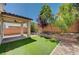 Cozy backyard features a covered patio, artificial grass, and mature landscaping at 9217 Valley Betica Ave, Las Vegas, NV 89148