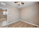 Bedroom with plank flooring, ceiling fan, and view into the attached bathroom at 9217 Valley Betica Ave, Las Vegas, NV 89148