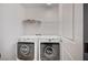 Functional laundry room with front load machines and wire shelving offers convenient chore space at 9217 Valley Betica Ave, Las Vegas, NV 89148