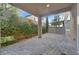 This back patio has a stone tiled floor and is surrounded by greenery and trees at 9327 Ettrick Ct, Las Vegas, NV 89178