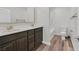 Bathroom with double sinks, dark wood cabinets, quartz countertops and tub-shower combo at 9327 Ettrick Ct, Las Vegas, NV 89178