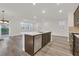 Modern kitchen with island seating, stainless appliances and backyard view in an open concept living space at 9327 Ettrick Ct, Las Vegas, NV 89178