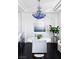 Dining room with blue crystal chandelier, white table, and sleek black hardwood floors at 9430 Laguna Niguel Dr # 203, Las Vegas, NV 89134