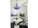 Elegant dining room with blue chandelier, white table, modern chairs, and sleek, dark wood flooring at 9430 Laguna Niguel Dr # 203, Las Vegas, NV 89134