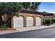 Exterior view of a three car garage with white doors and neutral paint at 9430 Laguna Niguel Dr # 203, Las Vegas, NV 89134