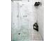 Modern shower with glass enclosure featuring stylish white marble walls and pebble tile flooring at 9430 Laguna Niguel Dr # 203, Las Vegas, NV 89134