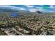 Aerial view of a Primary-planned community featuring a lush golf course, desert landscaping, and stunning mountain views at 9513 Yucca Blossom Dr, Las Vegas, NV 89134