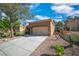 Inviting home exterior with a spacious driveway, desert landscaping, and an attached two-car garage at 9513 Yucca Blossom Dr, Las Vegas, NV 89134